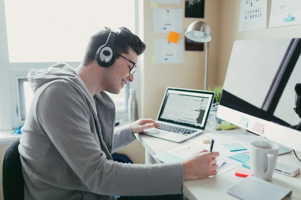 Student in dorm using laptop to find textbooks