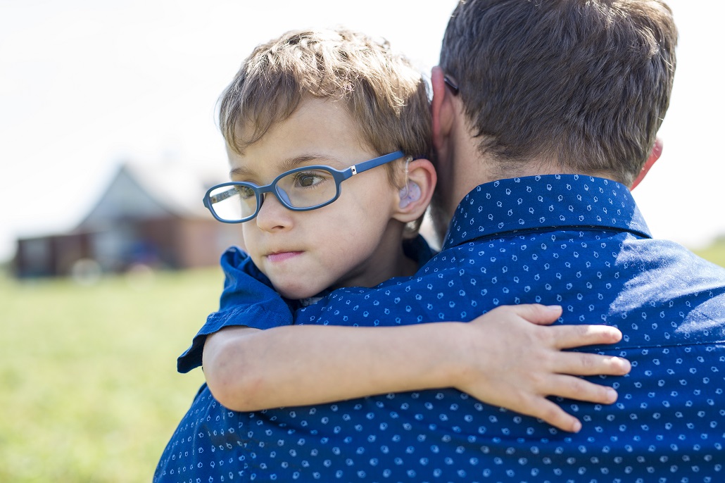 Father holding young son outside