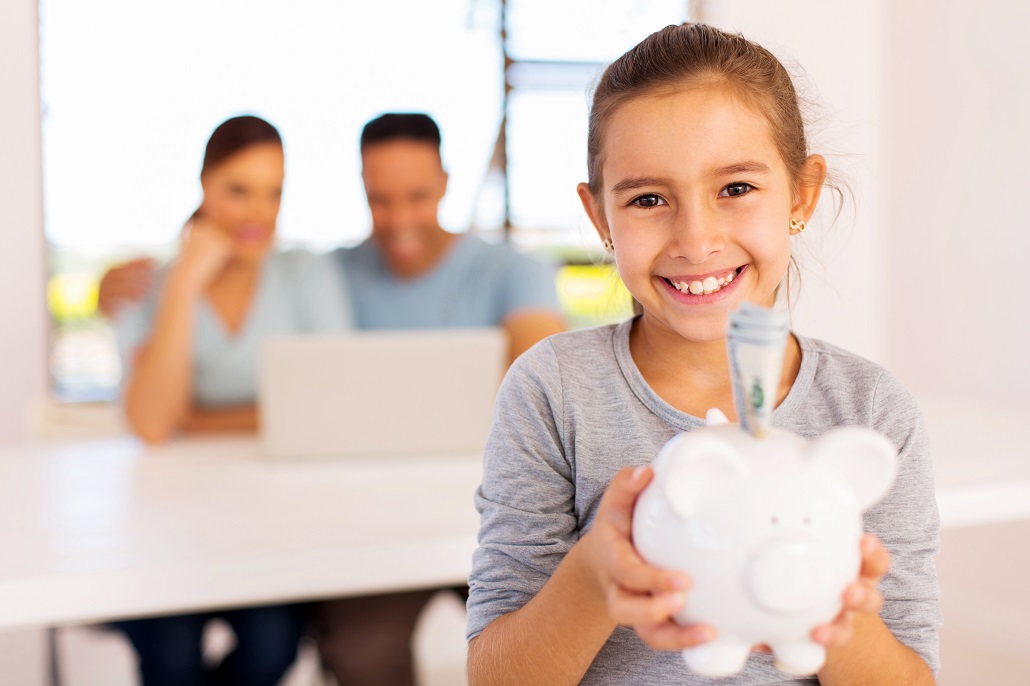 Young girl holding piggy bank