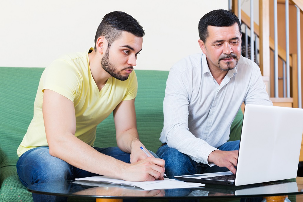 Father and son using computer to learn about co-borrowers