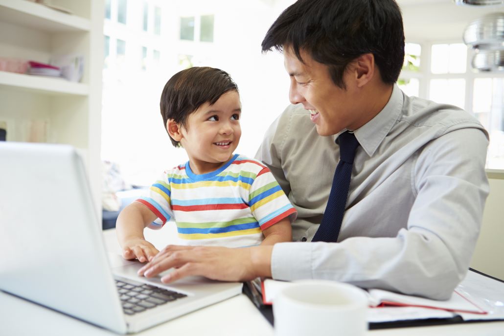 Father and young son reading college savings tips on a laptop