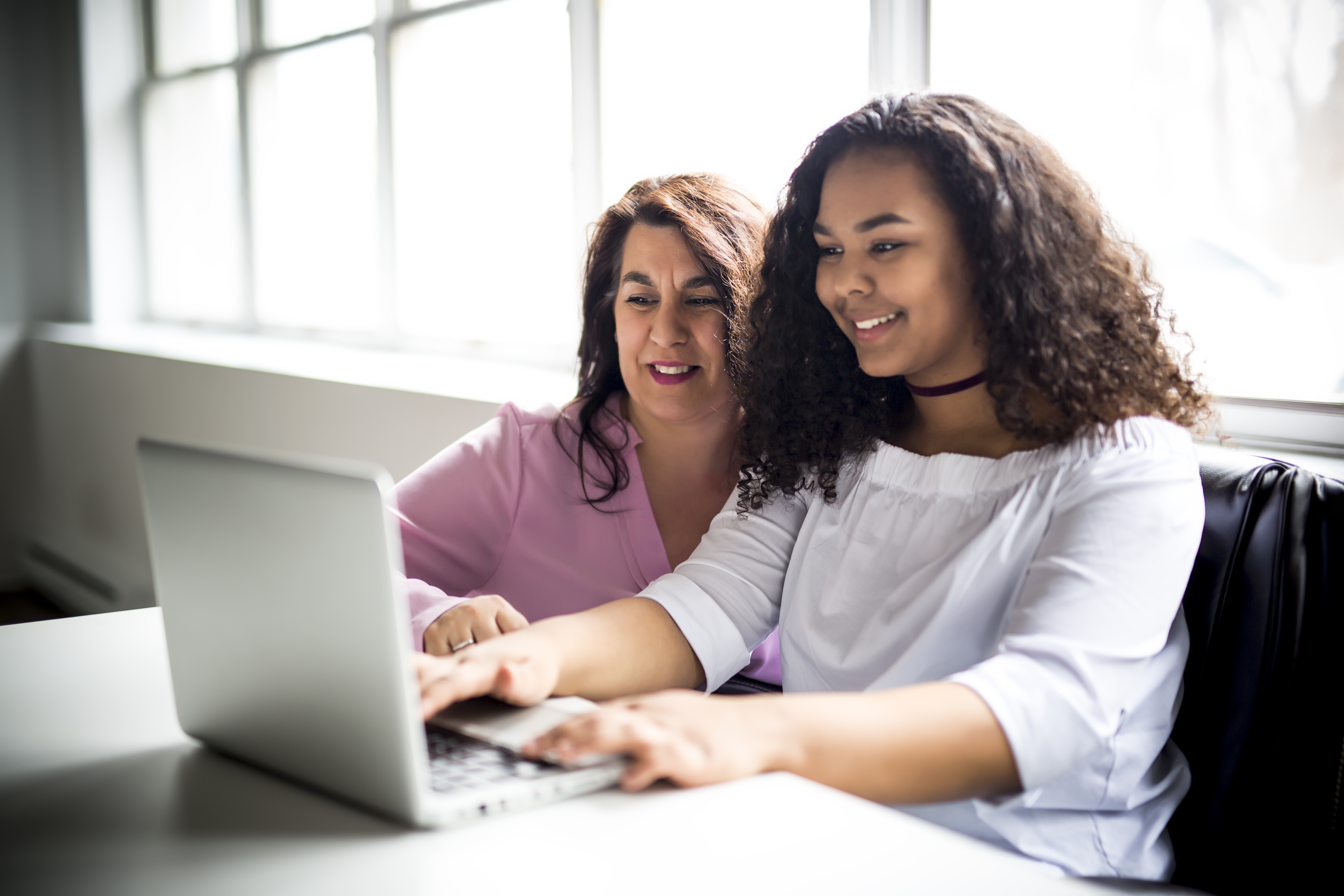 Student and school counselor completing the FAFSA on a laptop