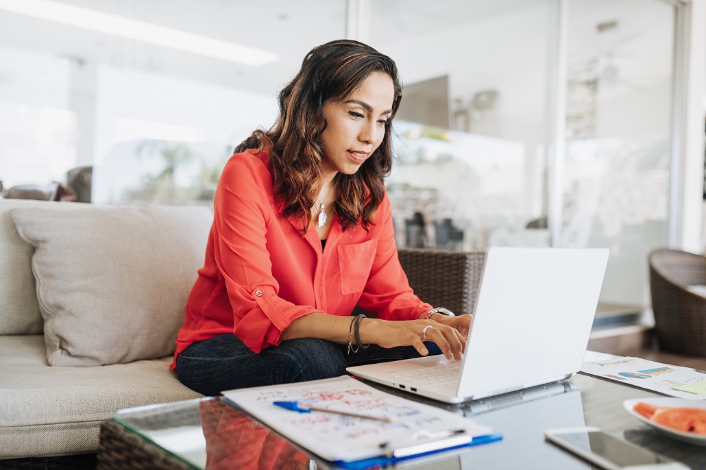 Woman using laptop to read FAQs about borrowing a loan