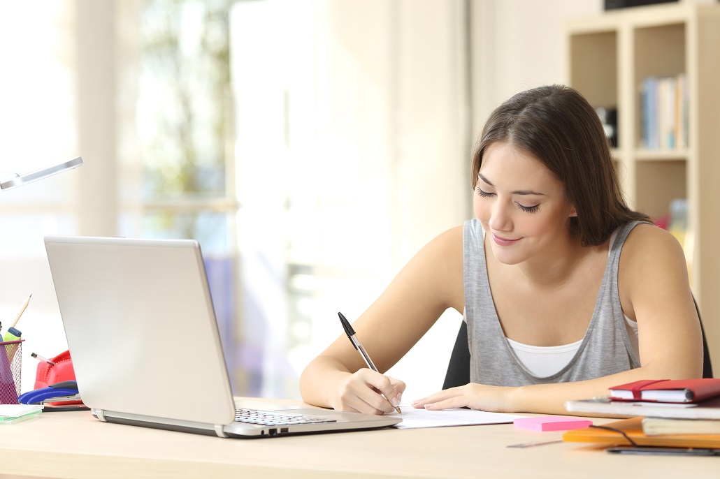 Girl using laptop to learn college essay mistakes to avoid