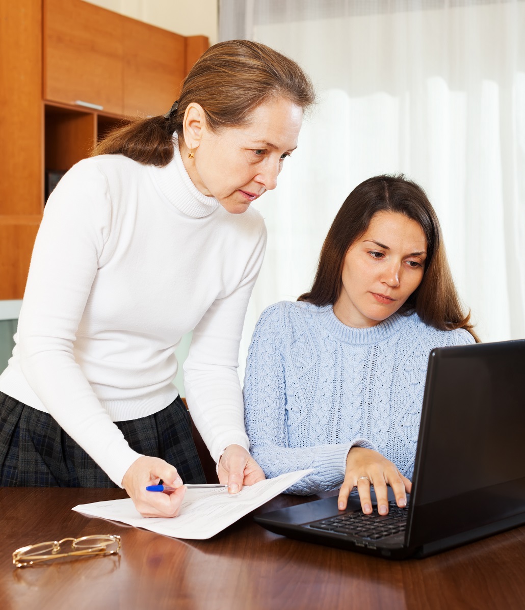 Mother and daughter using laptop together 