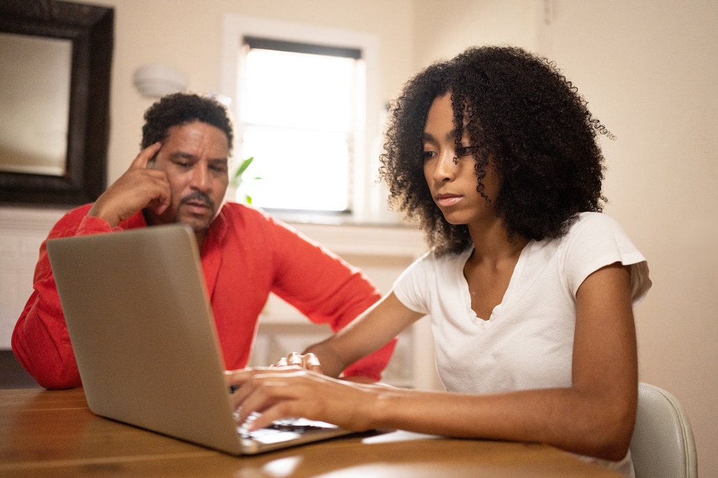 Father and daughter using computer to learn about MEFA Loans