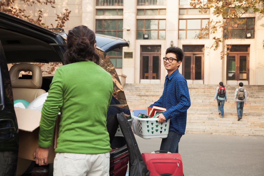 Mom helping freshman college student son move onto campus