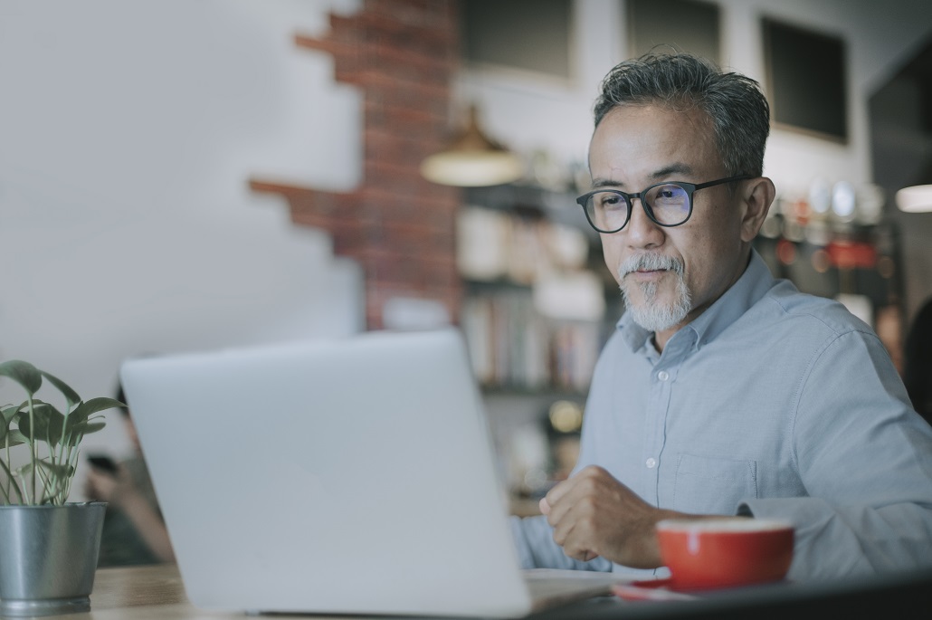 Man using laptop to learn about comparing financial aid offers