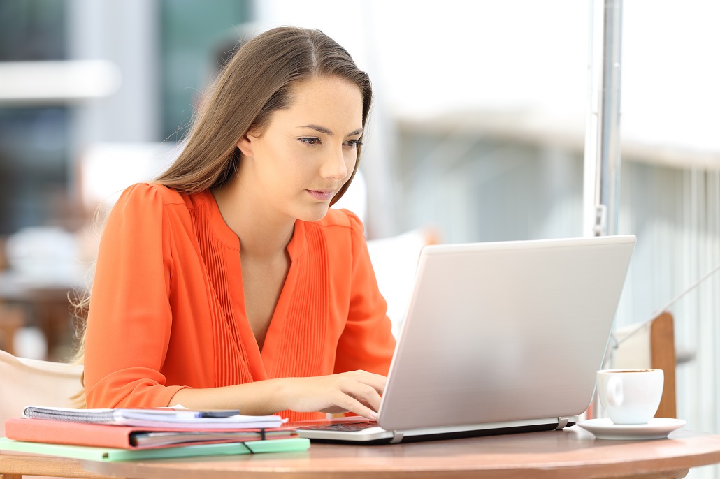 Young woman reading on a laptop about interest rates