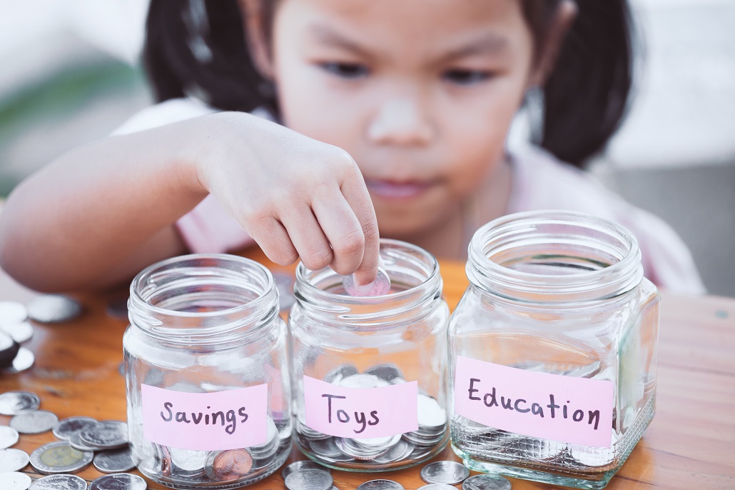 Child saving money for college in jars