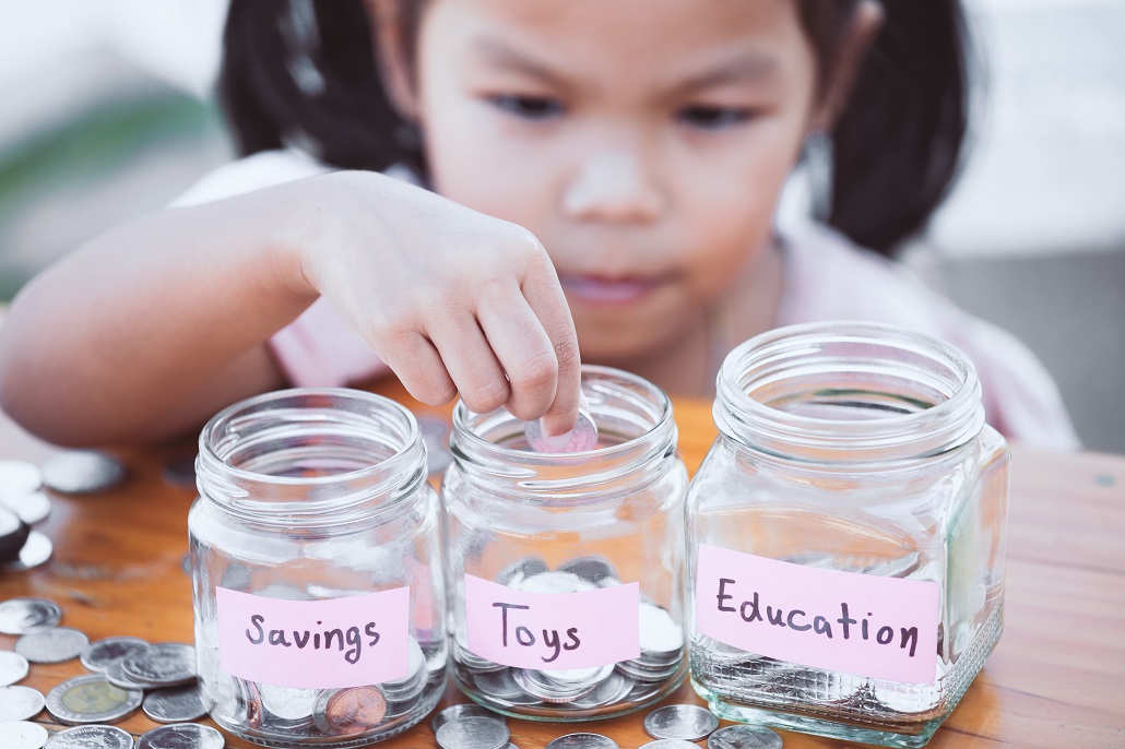 Child saving money for college in jars