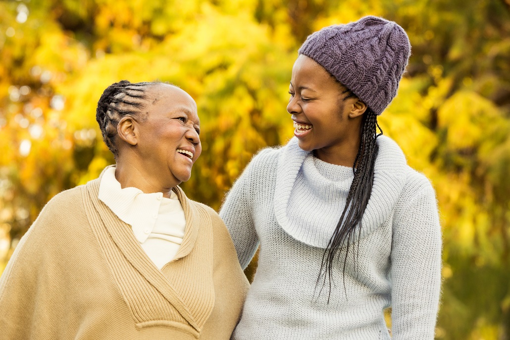 Grandmother and granddaughter smiling on college campus 