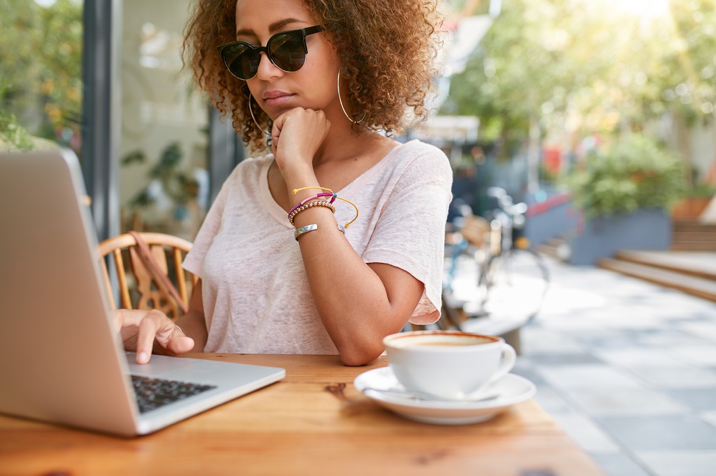 A young woman reading on a laptop about financial aid for undocumented students and parents