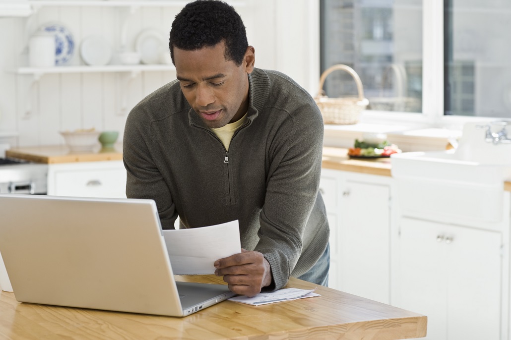 Man reviewing papers in kitchen 