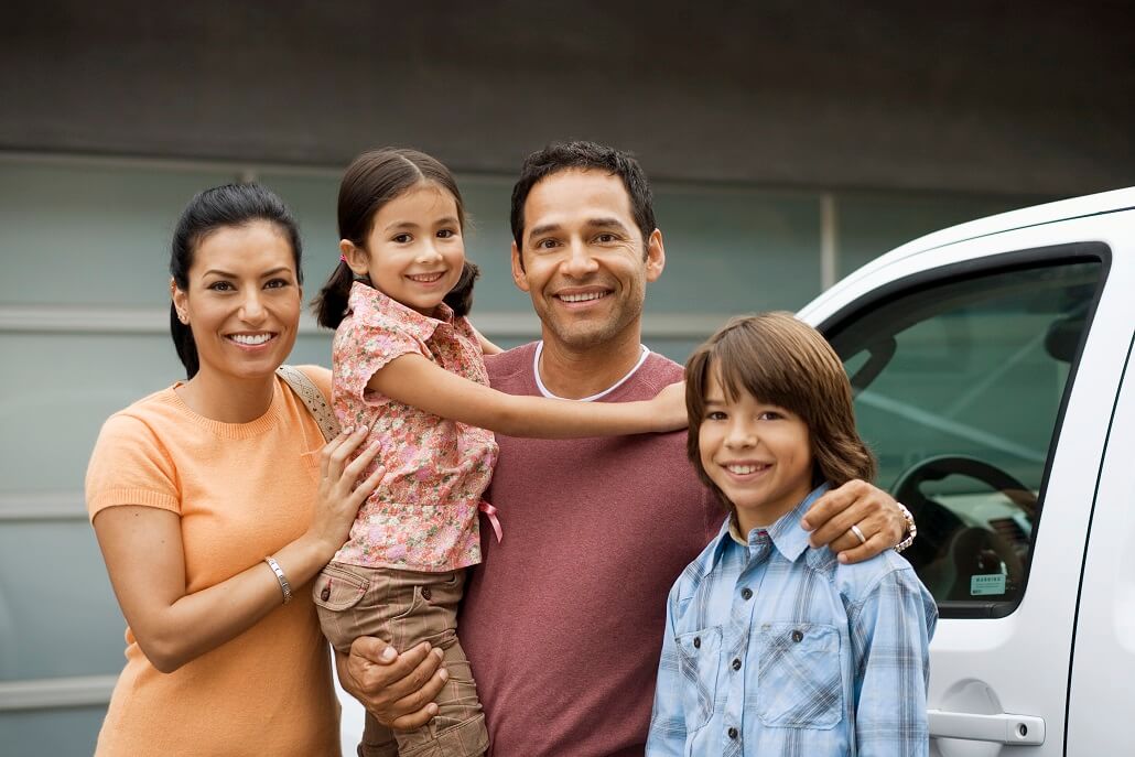 Two parents with two children standing outside together