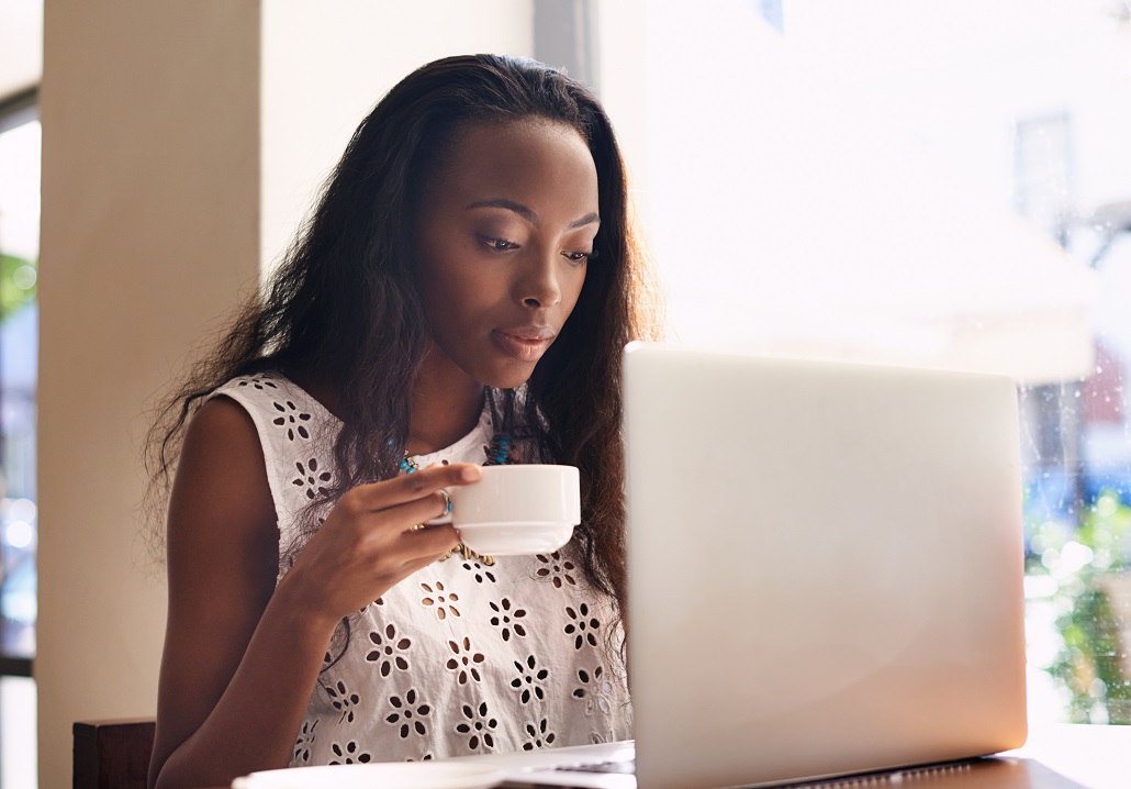 Young woman reading on a laptop about repaying federal student loans