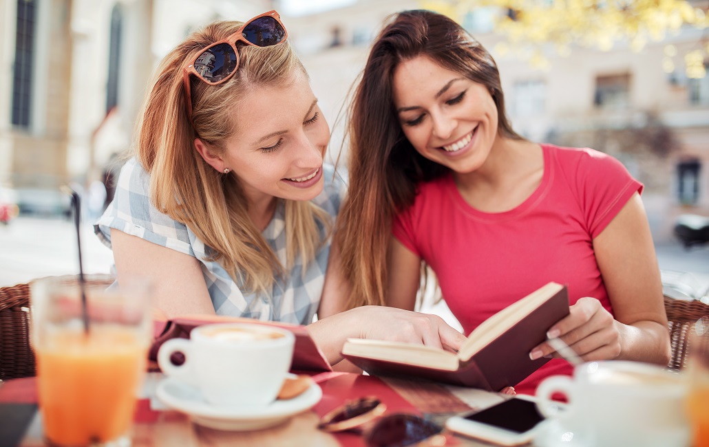 Students sitting in cafe reading about study abroad scholarships