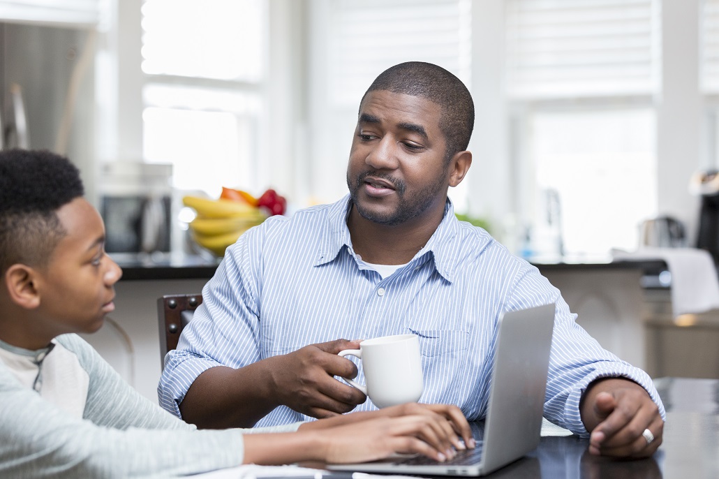 Father and son using computer to learn about saving for college