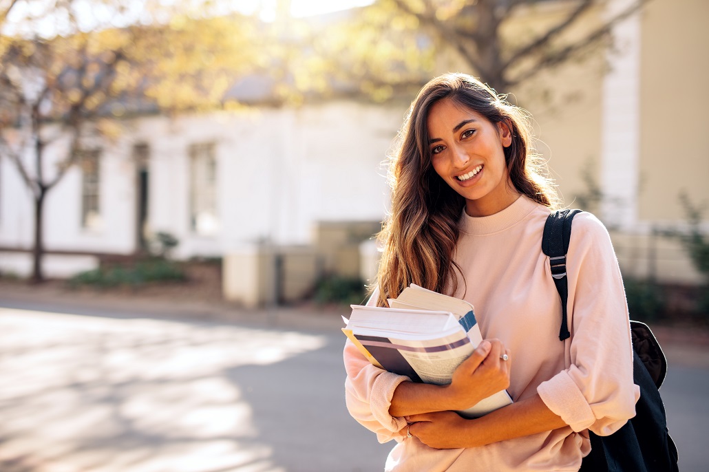 Girl holding books on campus