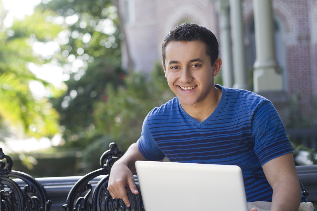 Boy outside using laptop 