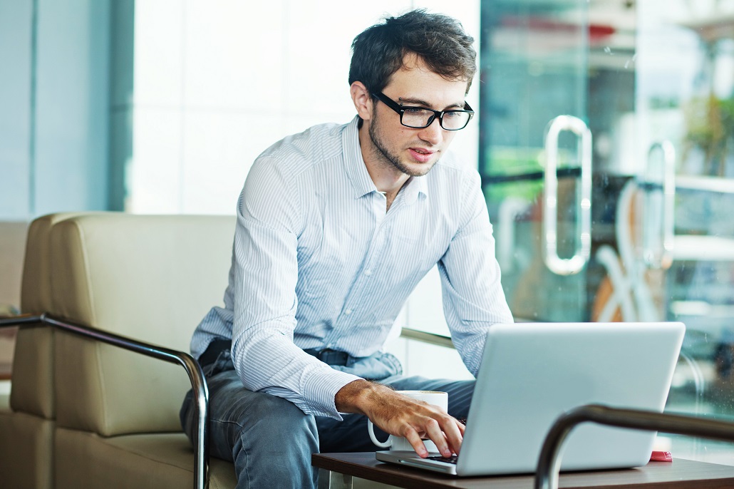 Man using computer to learn about refinancing student loans