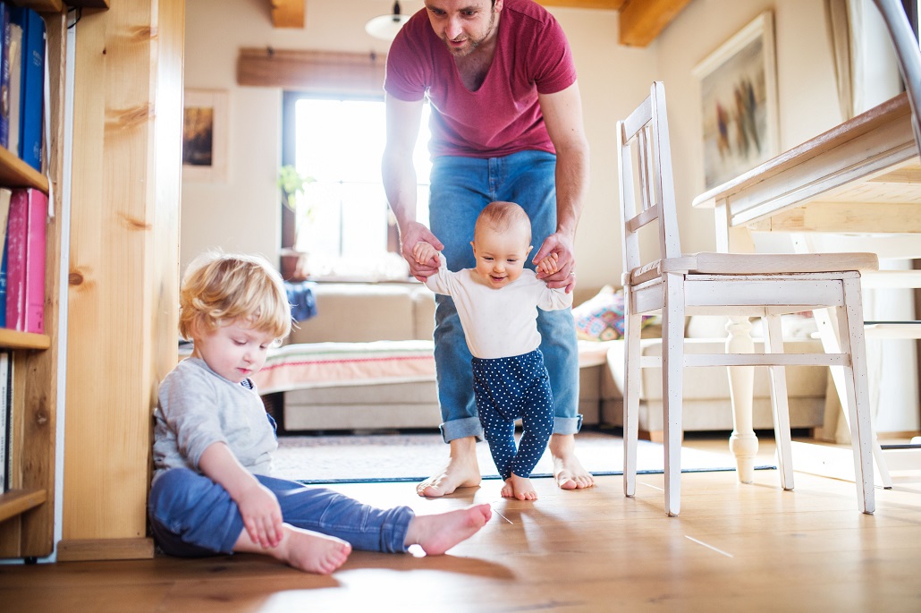 Father helping young son walk