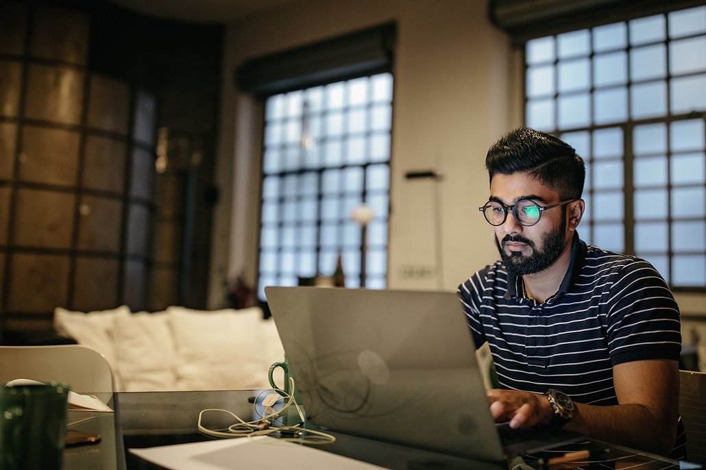 Man using laptop to learn about capitalized interest on student loans