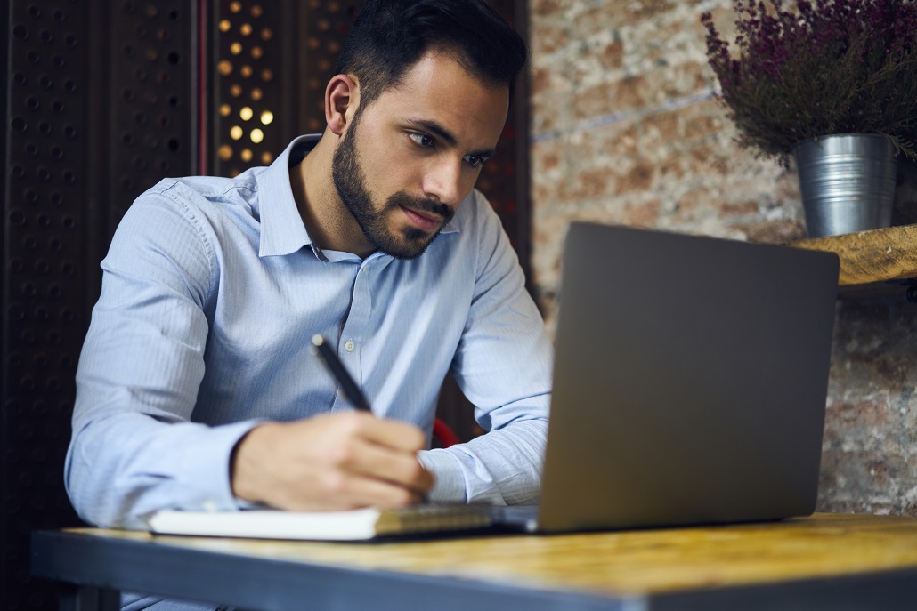 Man using laptop in cafe