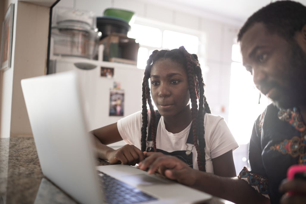 Father and daughter looking on a laptop at college admissions resources