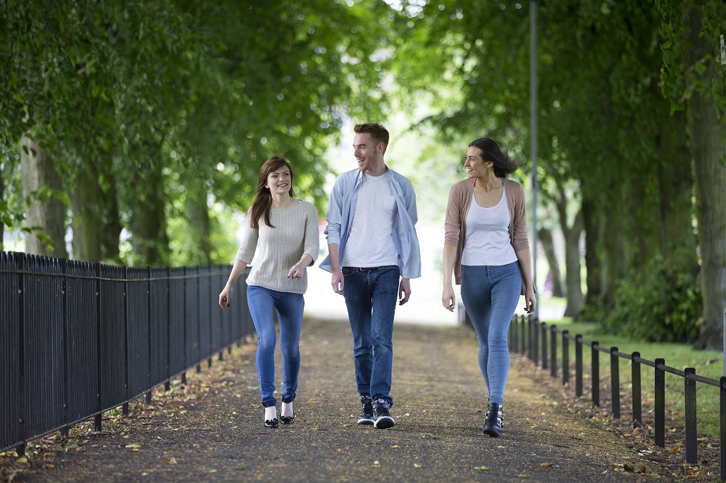 Students walking on campus talking about graduating in four years