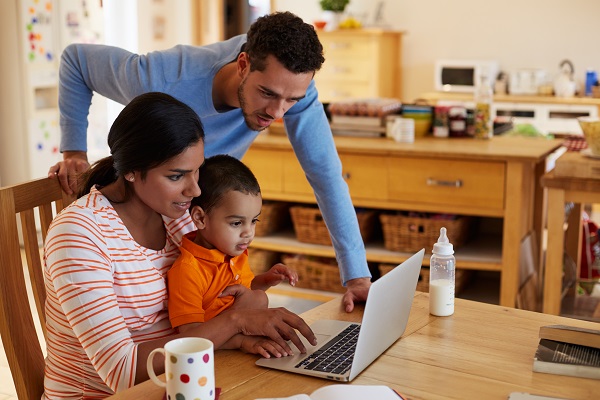 Parents with a young child on a laptop working on keeping their saving for college resolution