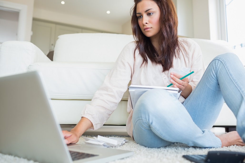 Young woman working on laptop to refinance her student loans
