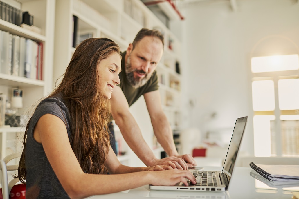Father and daughter using computer to learn how to save for college