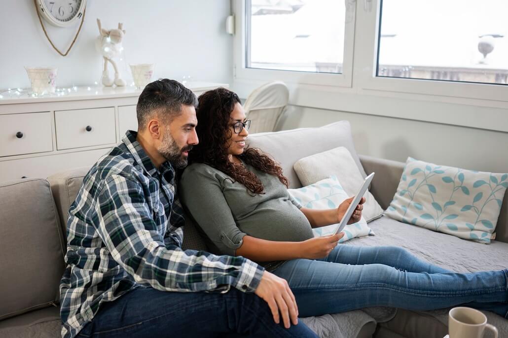 Couple sitting on couch reading about U.Fund's new rating on a tablet