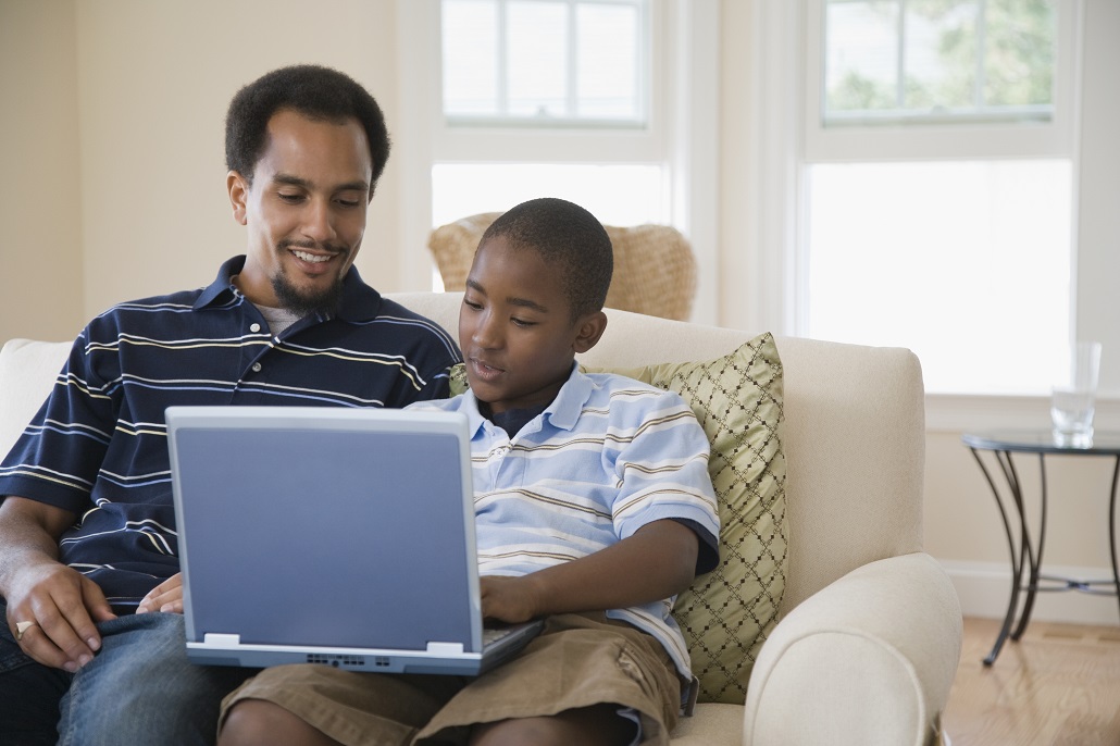 Father and son using laptop to view Boston Saves