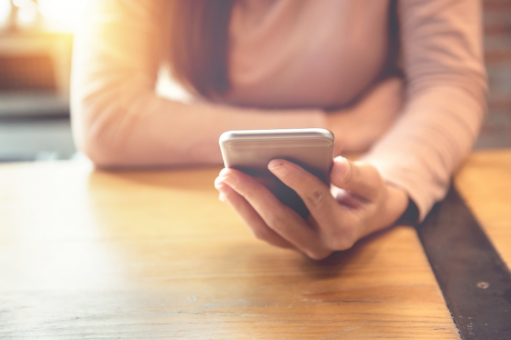 Woman using phone to switch to to Income-Driven Loan Repayment