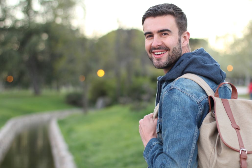 Transfer student standing outside with a backpack