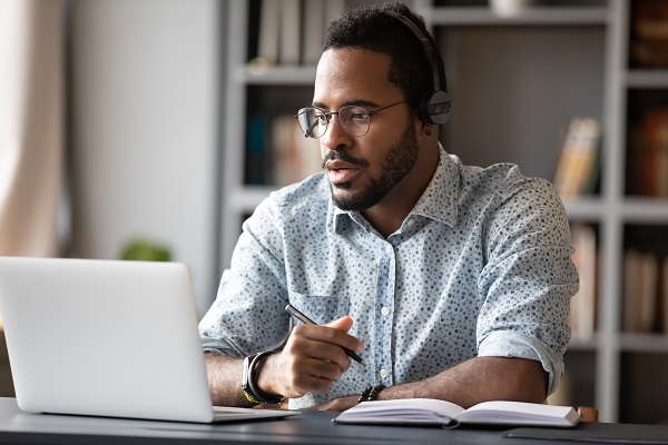 Man using laptop to learn about the expansion of Public Service Loan Forgiveness
