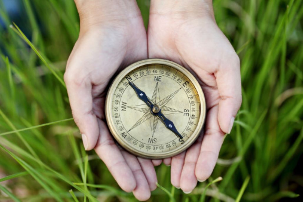 Hands holding a compass