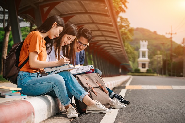 International college students sitting outside together