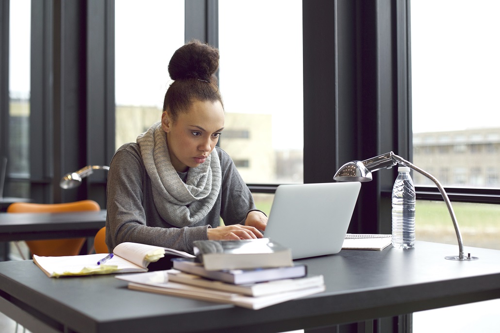 Student using laptop to learn how to handle stress during finals week