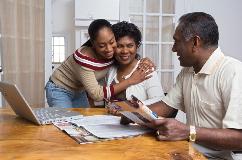 Daughter and parents at table planning for high school senior year