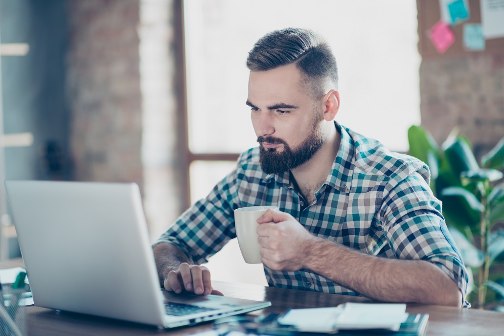 Man using laptop in cafe