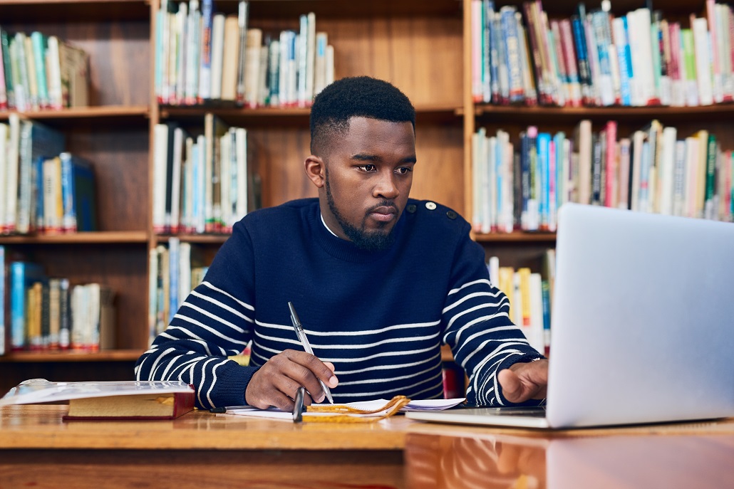 Student using computer to learn about borrowing loans to pay for college