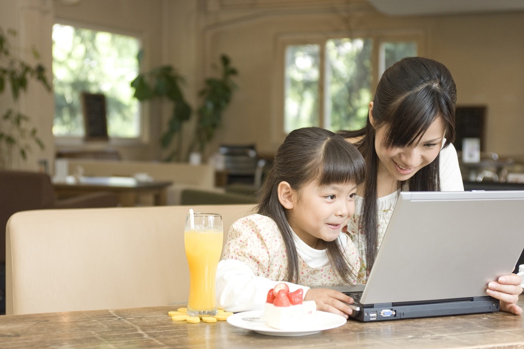 Mother and daughter using laptop together 