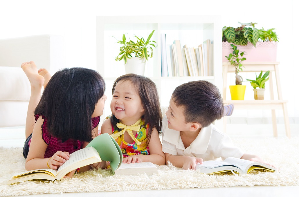 Three small children excited about reading together