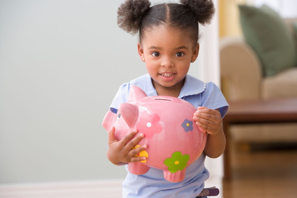 Young girl holding piggy bank