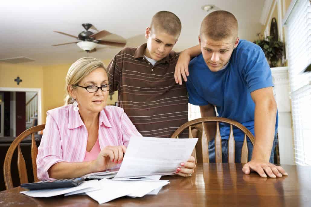 Mother going over paperwork with two sons