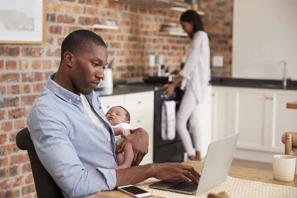 family in the kitchen with father holding a newborn