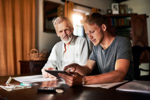 Two men consulting a tablet